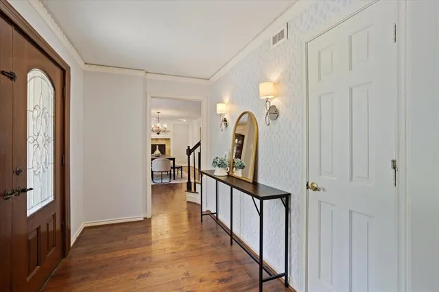 a view of a hallway with entryway wooden floor and windows