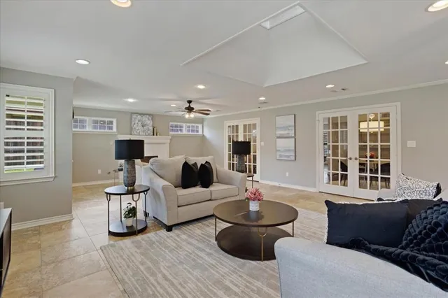 a living room with furniture and three windows