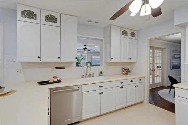 a kitchen with white cabinets and sink