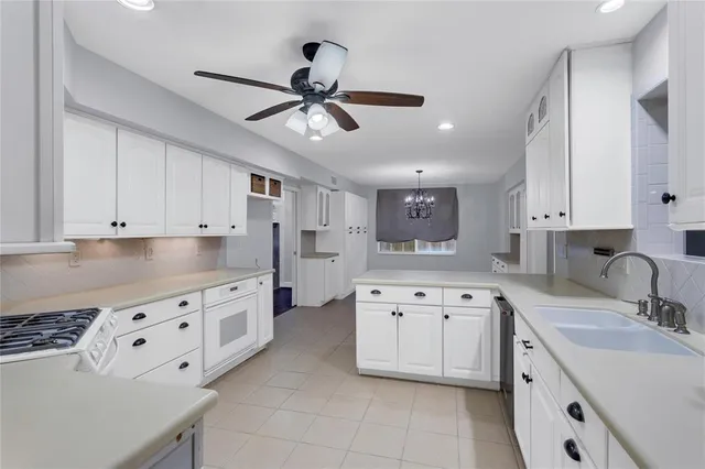 a kitchen with granite countertop a sink a stove and cabinets