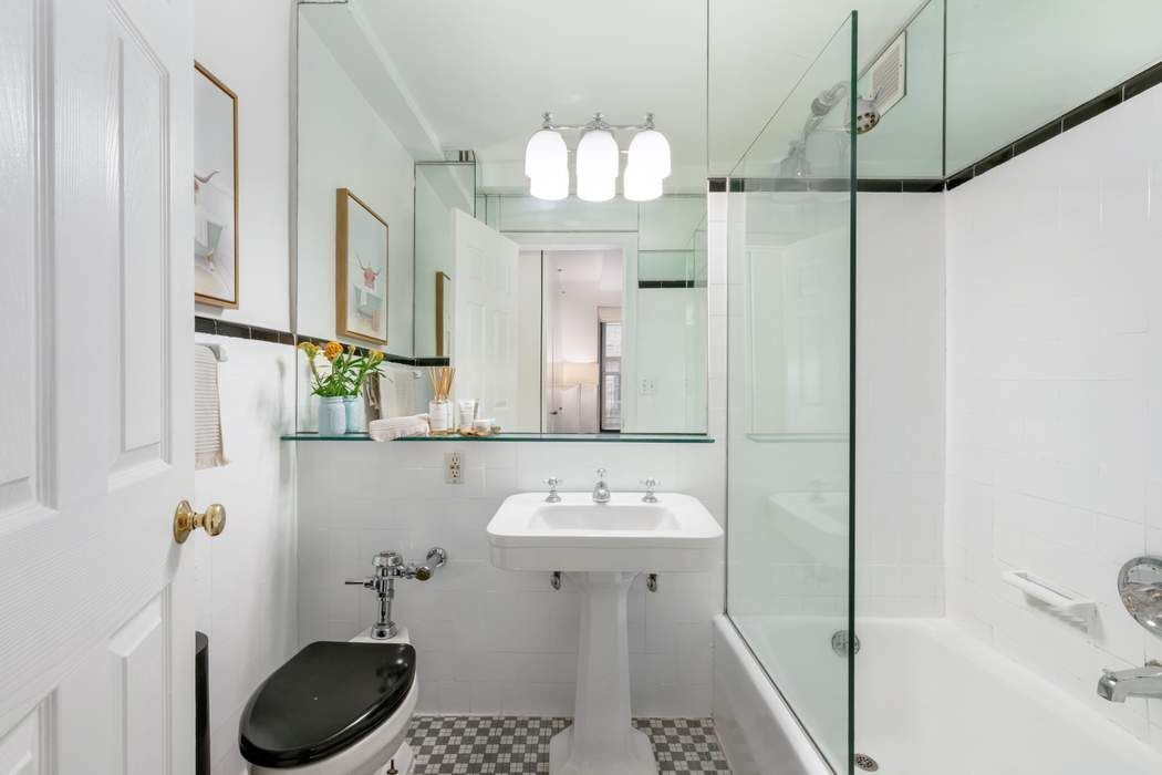1 5th Avenue, Unit 2J Manhattan, NY 10003 - Photo 10 of 19 a bathroom with a sink a toilet a mirror and shower