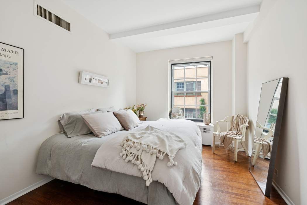 1 5th Avenue, Unit 2J Manhattan, NY 10003 - Photo 11 of 19 a bed sitting in a bedroom next to a window with a flat screen tv