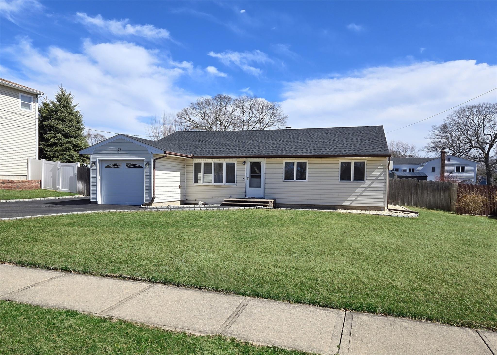 a view of a house with a big yard plants and large trees