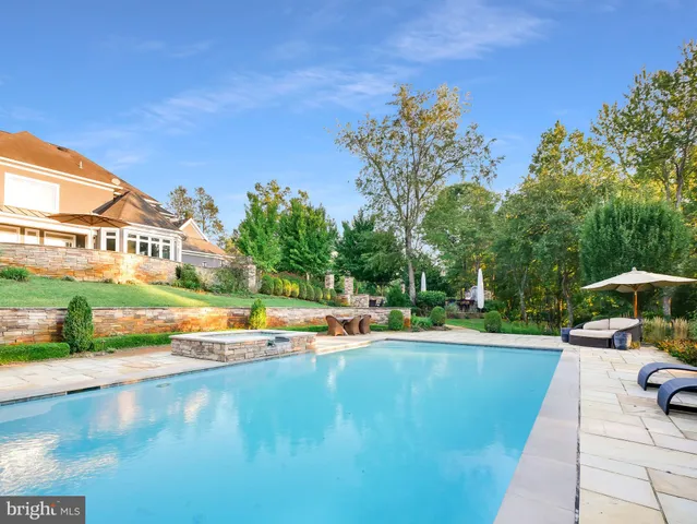 an aerial view of a house with swimming pool and porch with furniture