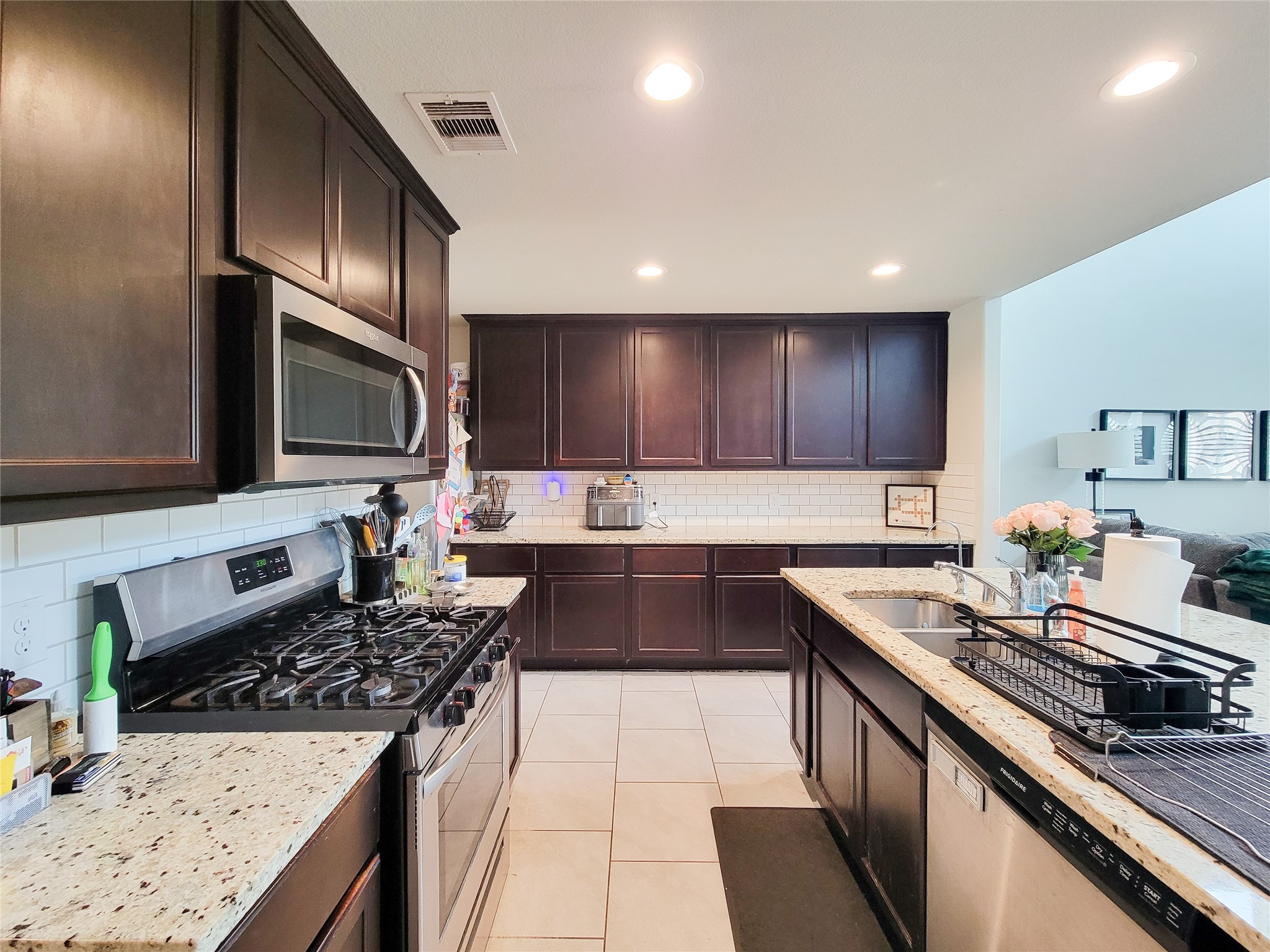 8003 Ecru Lane Rosharon, TX 77583 - Photo 6 of 35 a kitchen with granite countertop stainless steel appliances a sink a stove top oven a counter space and cabinets