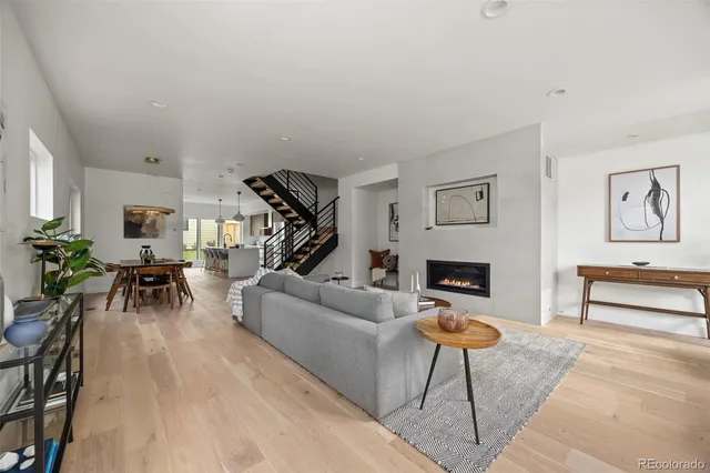 a living room with furniture a fireplace and a large window