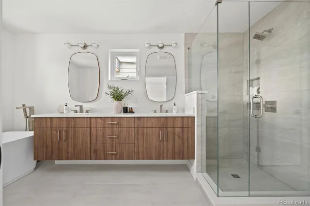 a bathroom with a double vanity sink mirror and shower