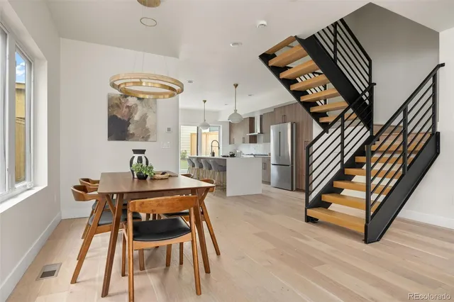 a kitchen with stainless steel appliances a refrigerator a sink appliances and a dining table