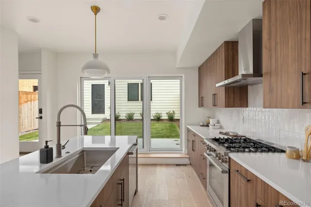 a kitchen with a stove a sink a dining table and chairs