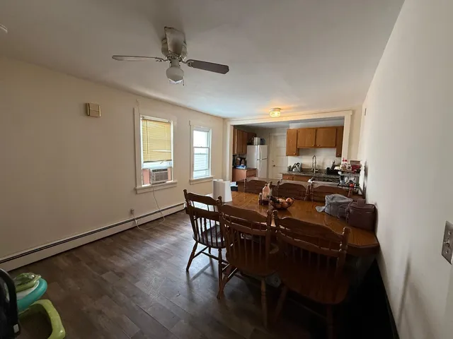 a view of a a dining room with furniture window and wooden floor