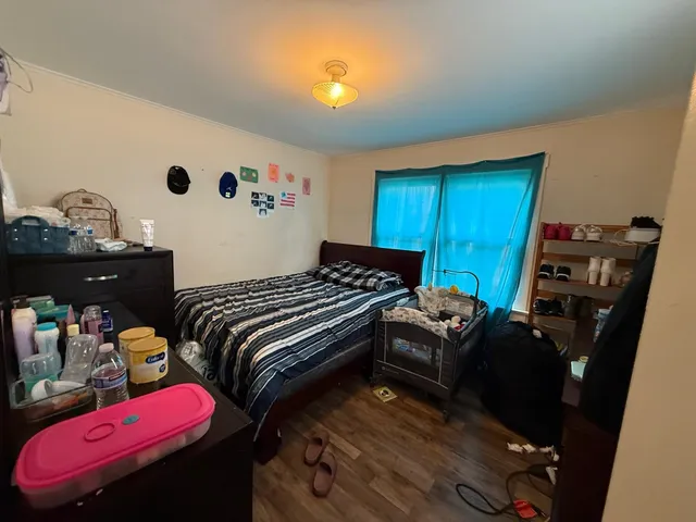 a bedroom with a bed and wooden floor