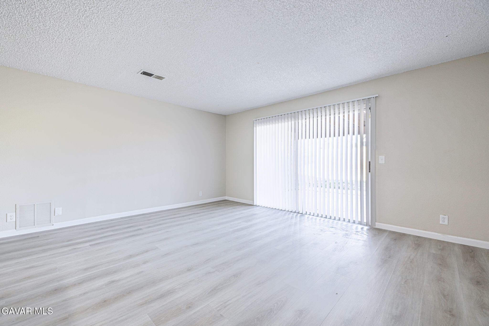 44422 Sancroft Avenue Lancaster, CA 93535 - Photo 13 of 35 a view of an empty room with wooden floor and a window
