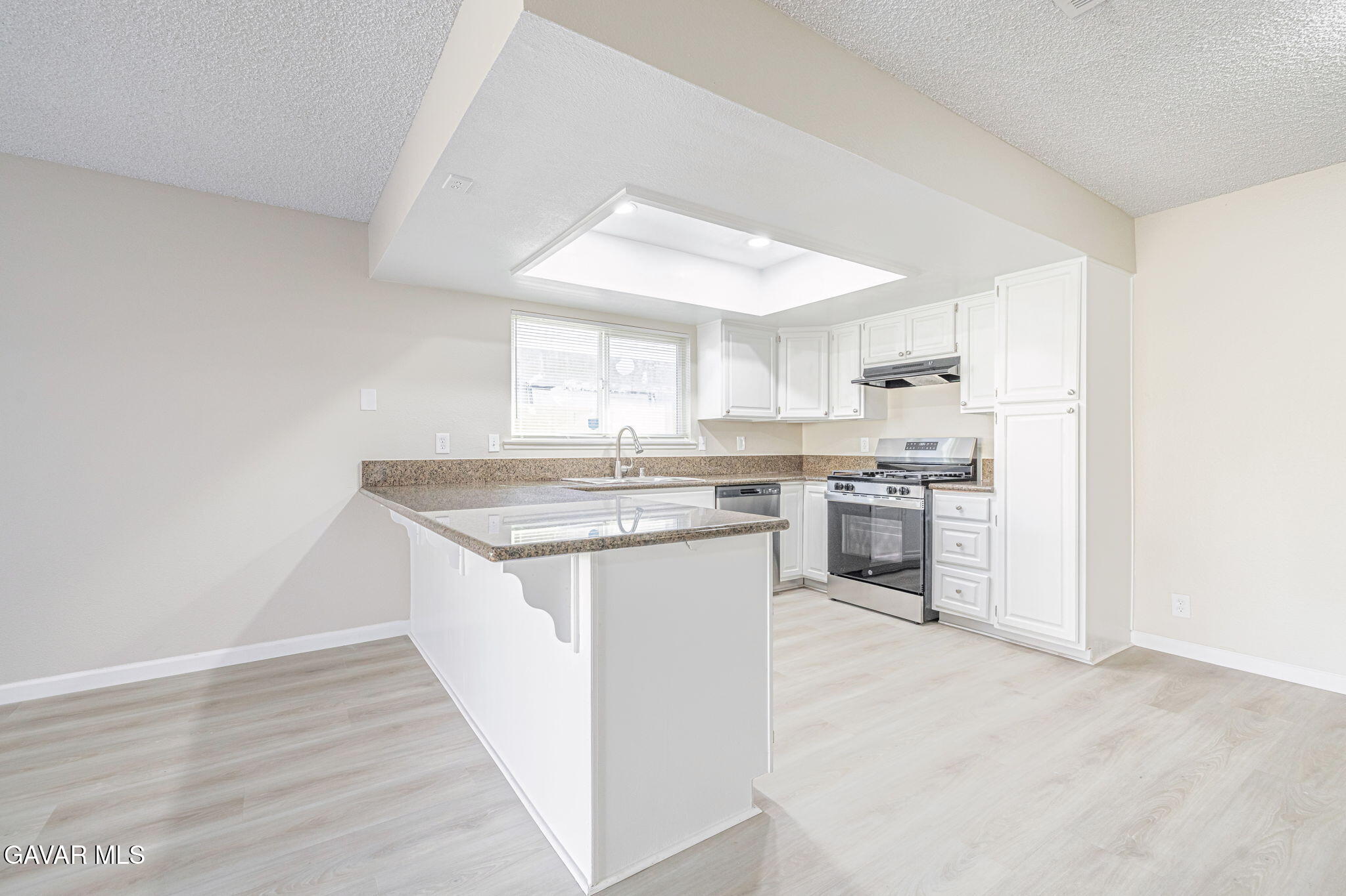 44422 Sancroft Avenue Lancaster, CA 93535 - Photo 15 of 35 a kitchen with a sink cabinets and wooden floor