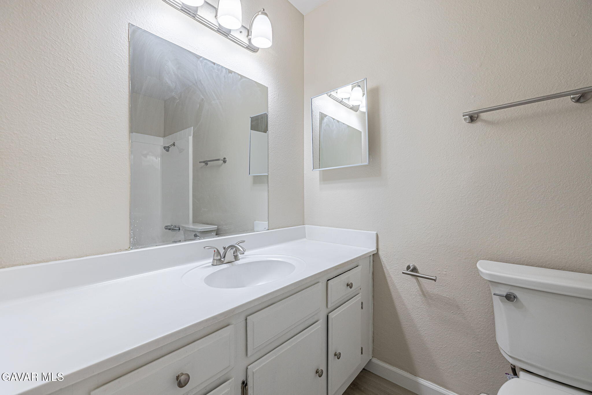 44422 Sancroft Avenue Lancaster, CA 93535 - Photo 18 of 35 a bathroom with a sink a toilet a mirror and vanity