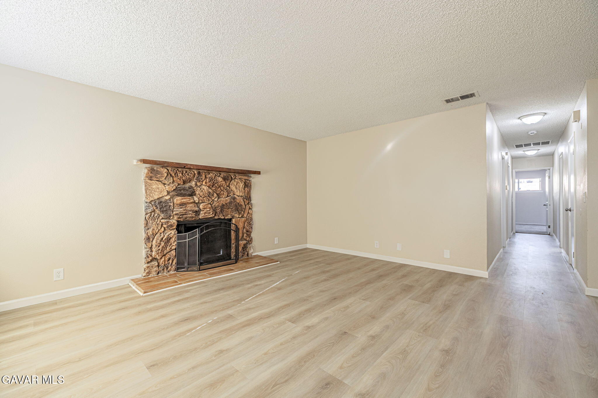 44422 Sancroft Avenue Lancaster, CA 93535 - Photo 6 of 35 a view of a livingroom with wooden floor and a fireplace