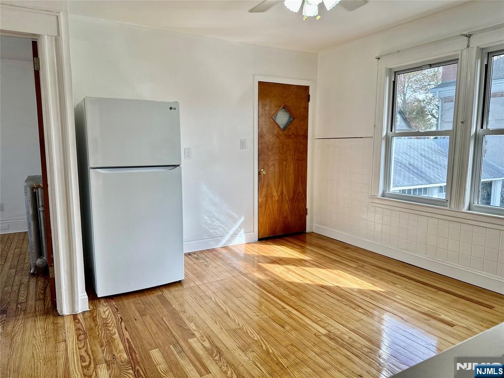 227 Hamilton Avenue, Unit 2 Hasbrouck Heights, NJ 07604 - Photo 12 of 27 a view of an empty room with wooden floor and a window