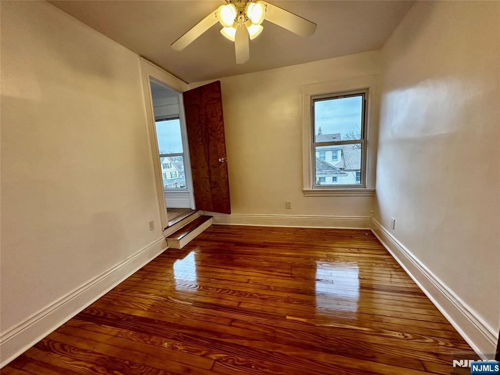 227 Hamilton Avenue, Unit 2 Hasbrouck Heights, NJ 07604 - Photo 16 of 27 a view of an empty room with window and wooden floor