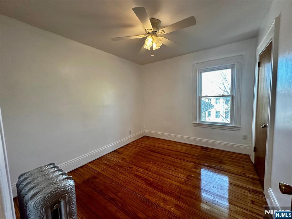 227 Hamilton Avenue, Unit 2 Hasbrouck Heights, NJ 07604 - Photo 19 of 27 a view of empty room with wooden floor and fan