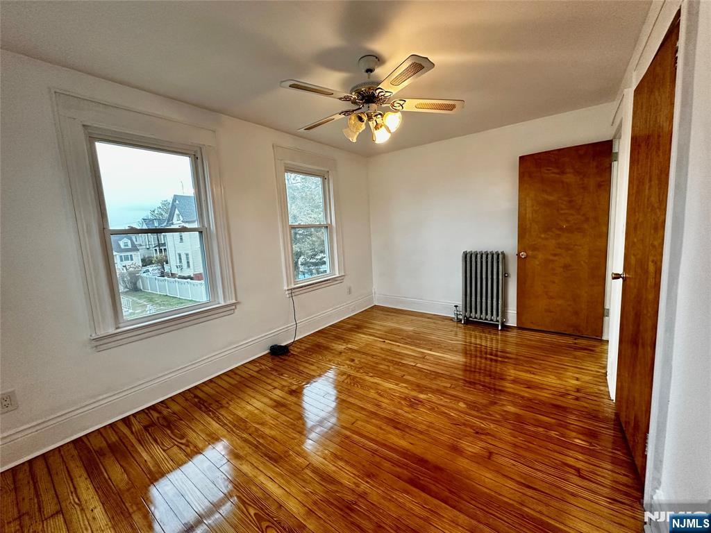 227 Hamilton Avenue, Unit 2 Hasbrouck Heights, NJ 07604 - Photo 21 of 27 a view of an empty room with a window and wooden floor