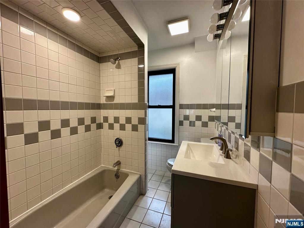 227 Hamilton Avenue, Unit 2 Hasbrouck Heights, NJ 07604 - Photo 22 of 27 a bathroom with a bathtub a sink a mirror and shower