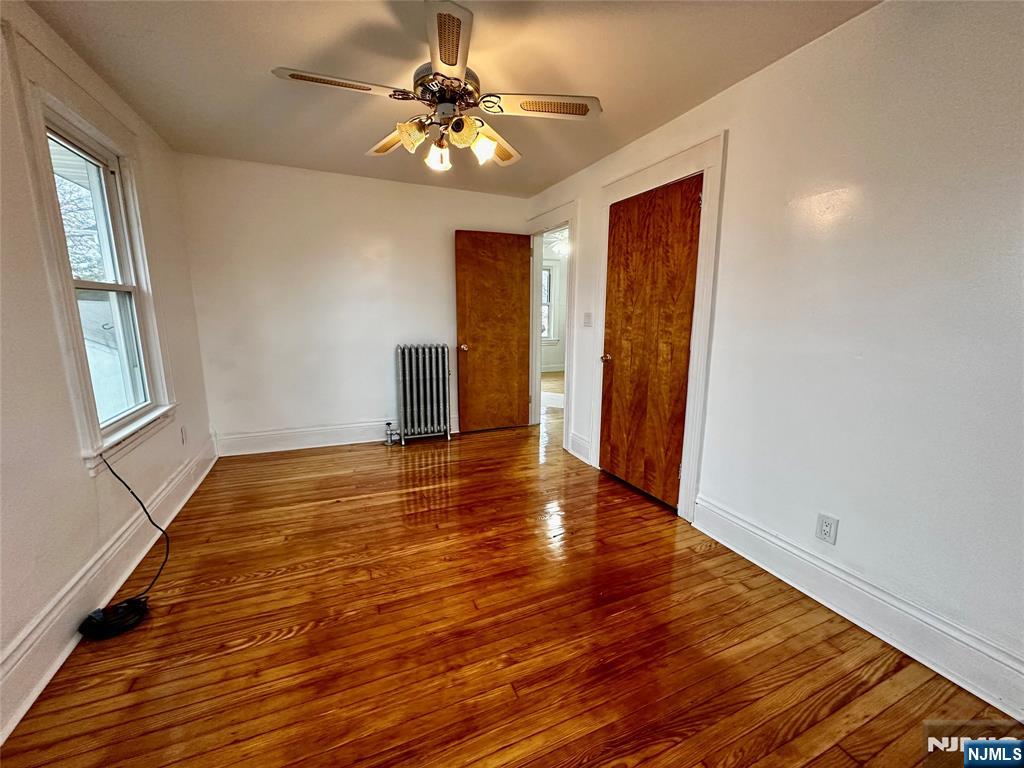 227 Hamilton Avenue, Unit 2 Hasbrouck Heights, NJ 07604 - Photo 3 of 27 a view of an empty room with wooden floor and a window