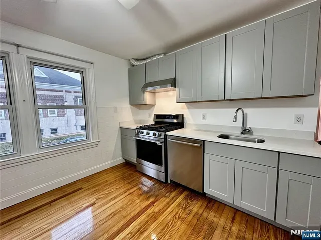 a kitchen with granite countertop wooden cabinets a sink and dishwasher
