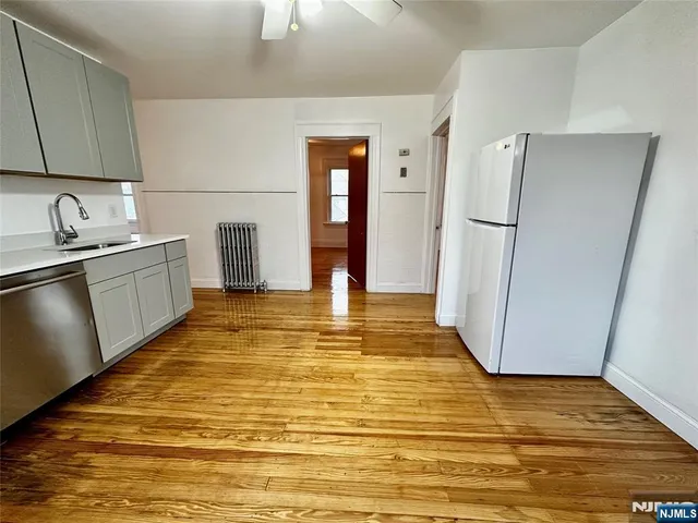 a view of a kitchen with wooden floor and electronic appliances