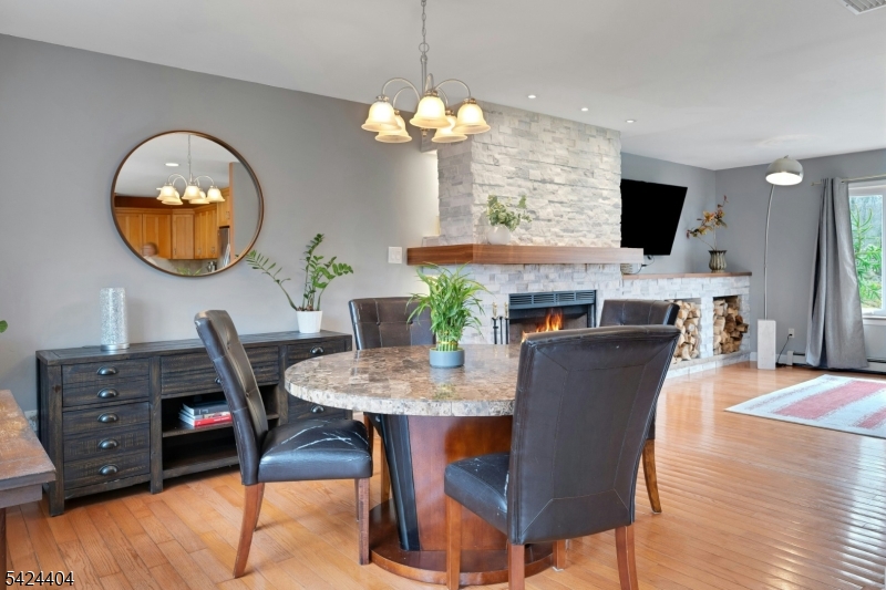 4 Andover Mohawk Road Sparta, NJ 07871 - Photo 11 of 35 a dining room with wooden floor a chandelier a wooden table and chairs
