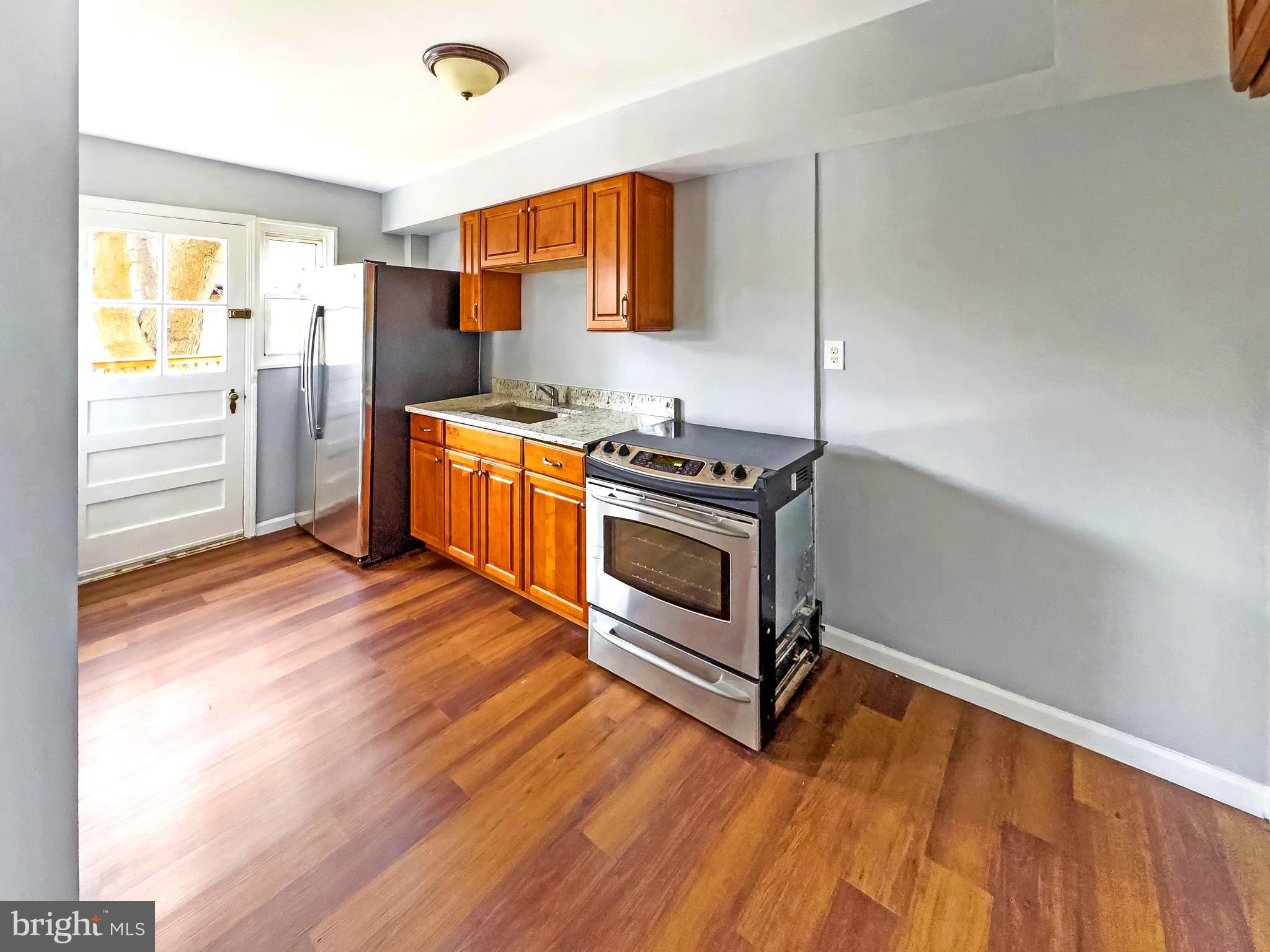 5515 Channing Road Baltimore, MD 21229 - Photo 4 of 10 a kitchen with stainless steel appliances granite countertop a stove a sink and a refrigerator