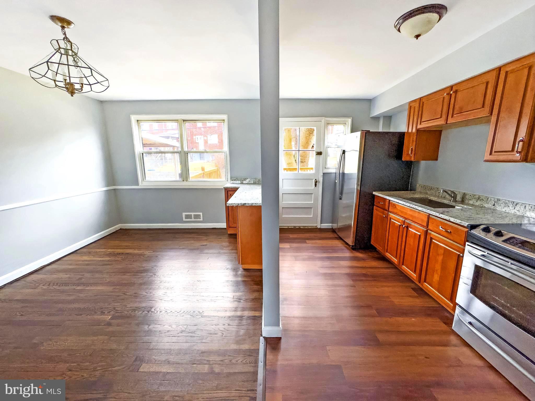 5515 Channing Road Baltimore, MD 21229 - Photo 5 of 10 an empty room with wooden floor and windows