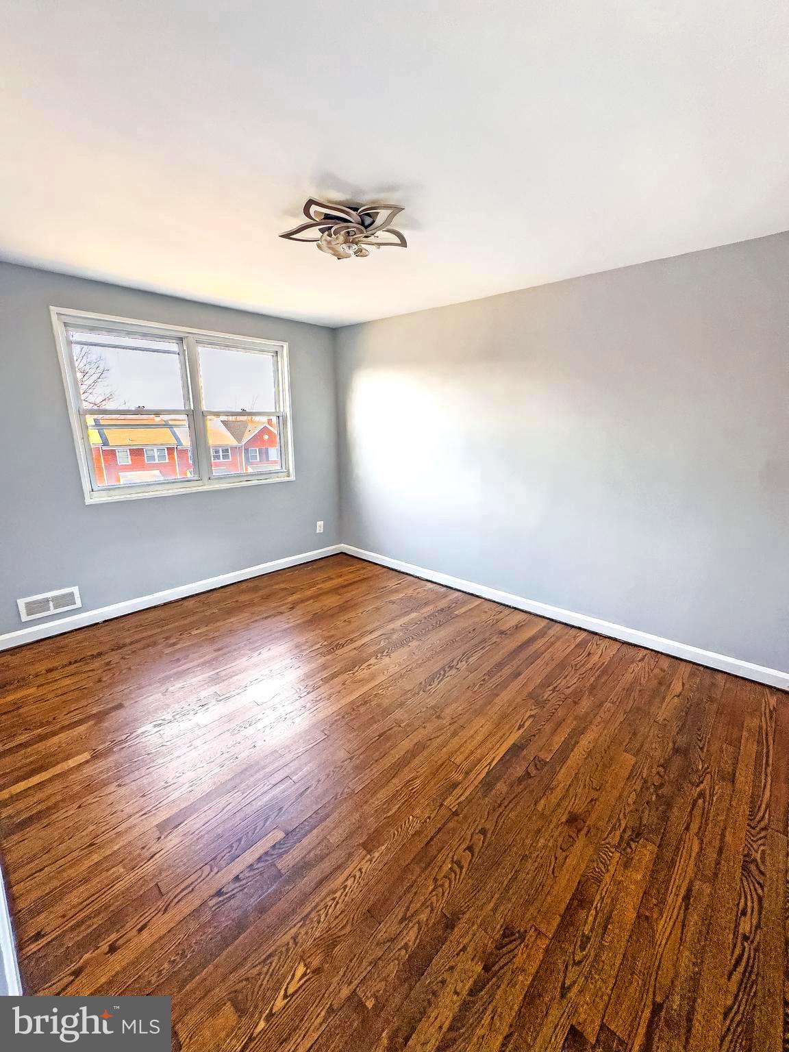5515 Channing Road Baltimore, MD 21229 - Photo 6 of 10 an empty room with wooden floor and window
