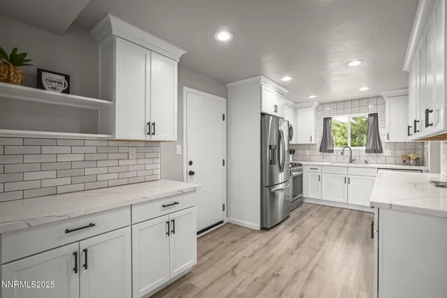 a kitchen with white cabinets and stainless steel appliances