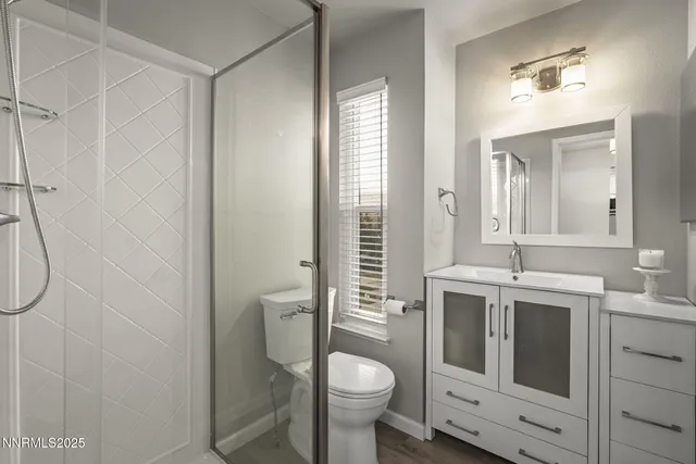 a bathroom with a granite countertop toilet sink and mirror