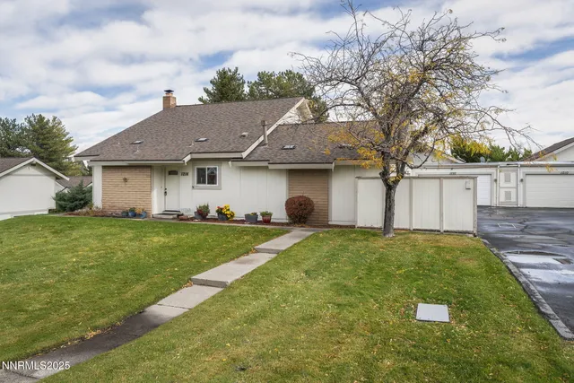 a view of a yard in front of a house with large tree