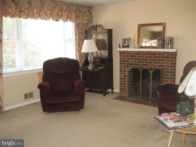 8710 Edmonston Road Berwyn Heights, MD 20740 - Photo 11 of 13 a living room with furniture and a fireplace
