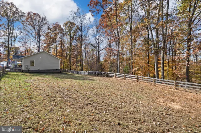 a view of a yard with wooden fence