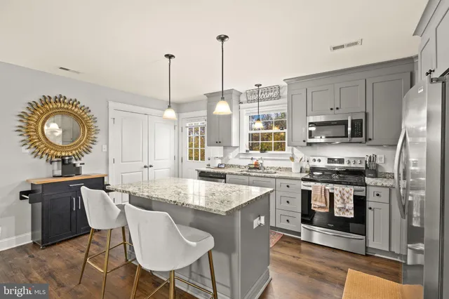 a kitchen with stainless steel appliances granite countertop a stove a sink and a refrigerator