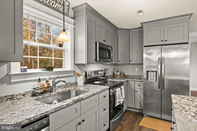 a kitchen with stainless steel appliances granite countertop a sink stove and refrigerator