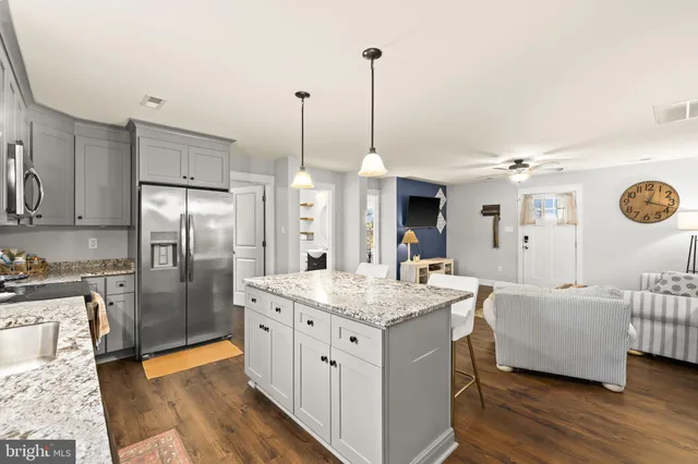a kitchen with stainless steel appliances kitchen island granite countertop a sink a refrigerator and a stove