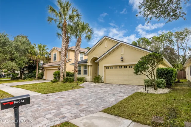 a front view of a house with a garden and trees