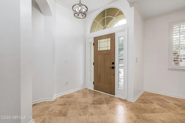 a view of a room with a chandelier fan and windows