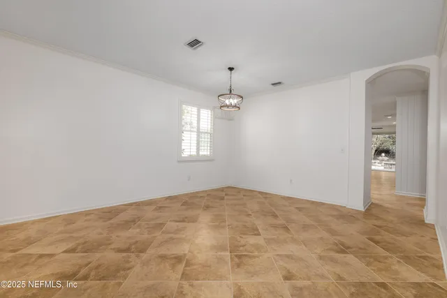a kitchen with kitchen island granite countertop a stove a sink and white cabinets
