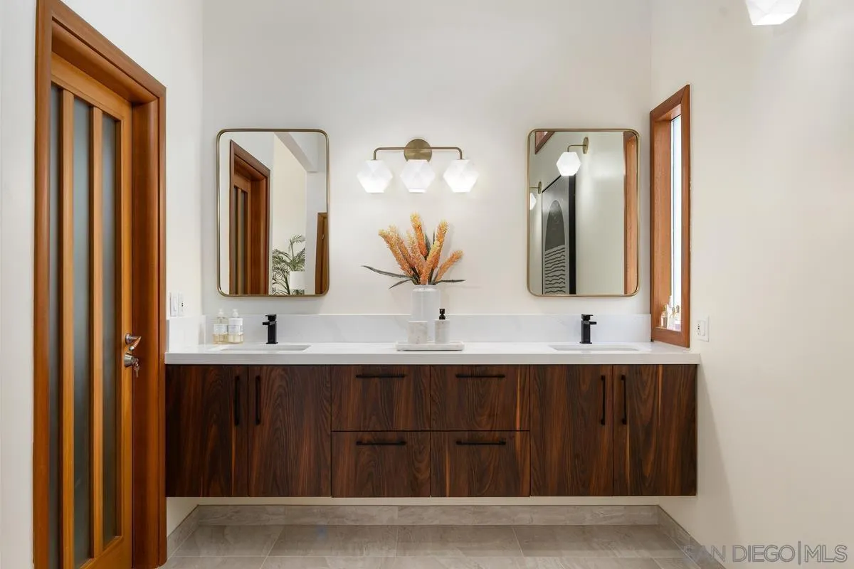 7911 El Paseo Grande La Jolla, CA 92037 - Photo 15 of 32 a bathroom with a double vanity sink and mirror