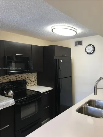 a kitchen with stainless steel appliances granite countertop a refrigerator and a stove