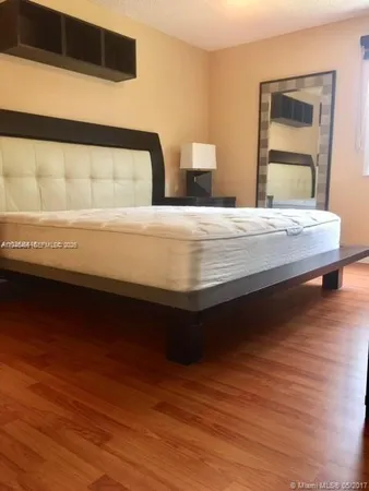 a view of a small space with wooden floor and wardrobe