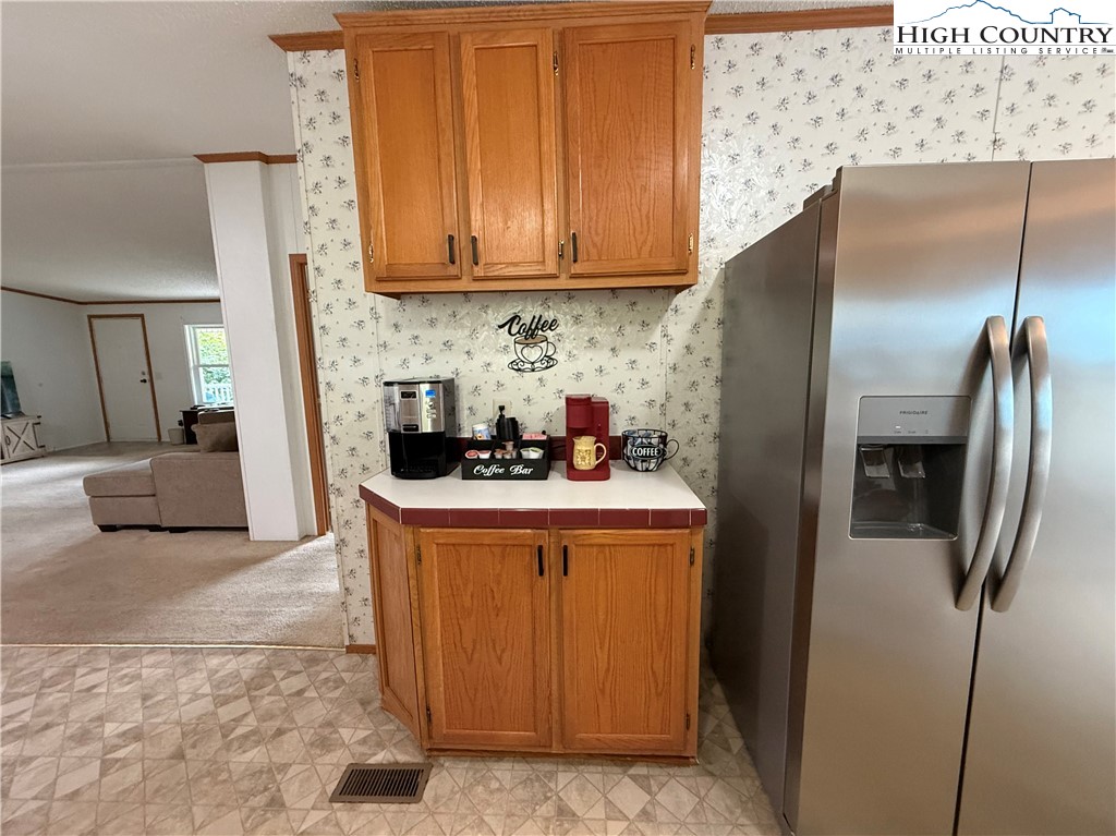 304 The Mulberry Cove Road Boone, NC 28607 - Photo 12 of 45 a kitchen with stainless steel appliances granite countertop a refrigerator a stove and a sink with wooden floor