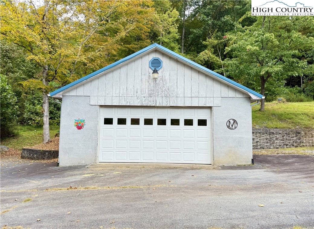 304 The Mulberry Cove Road Boone, NC 28607 - Photo 34 of 45 a view of a white house with a yard and large tree