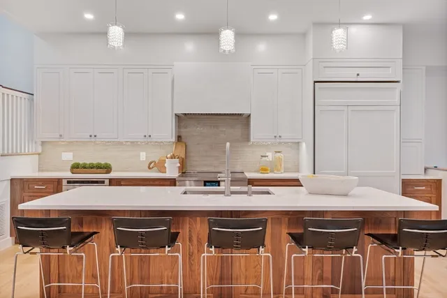 a kitchen with kitchen island a counter top space a sink stainless steel appliances and cabinets