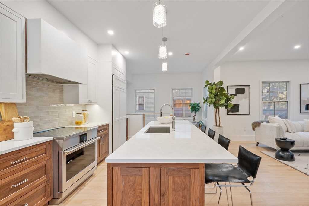 65 Francis Street Brookline, MA 02446 - Photo 12 of 35 a kitchen with kitchen island a counter top space a sink stainless steel appliances and cabinets