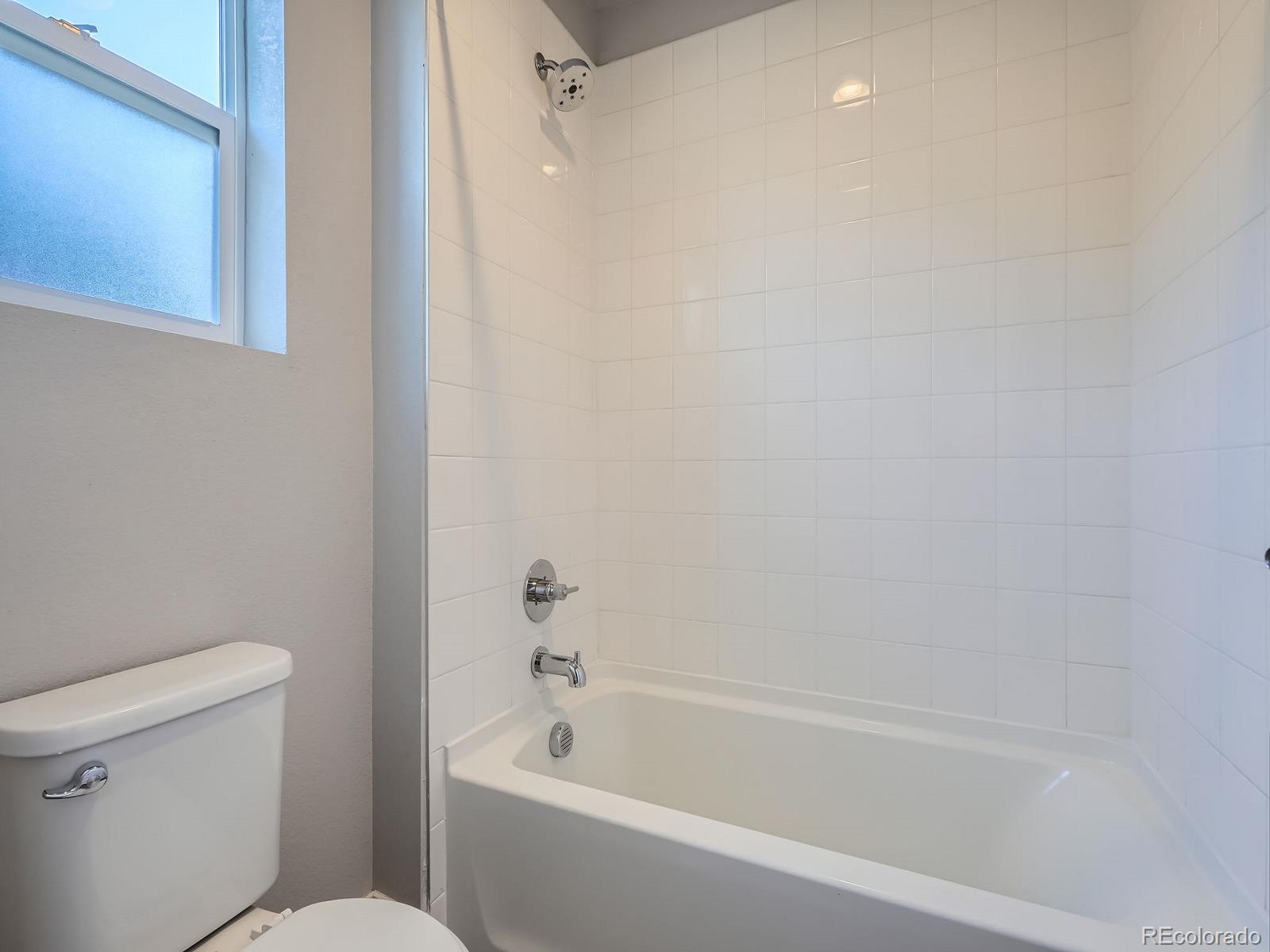 4773 Kittredge Street Denver, CO 80239 - Photo 21 of 32 a white bath tub sitting next to a white toilet